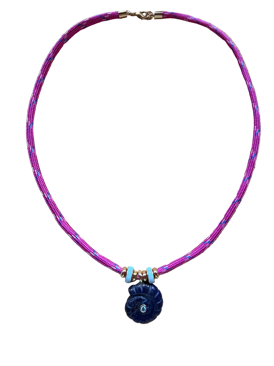 A beaded necklace featuring a vibrant magenta-pink and purple woven cord, accented with small gold-toned beads, light blue spacer beads, and a dark blue spiral shell pendant with a turquoise center.