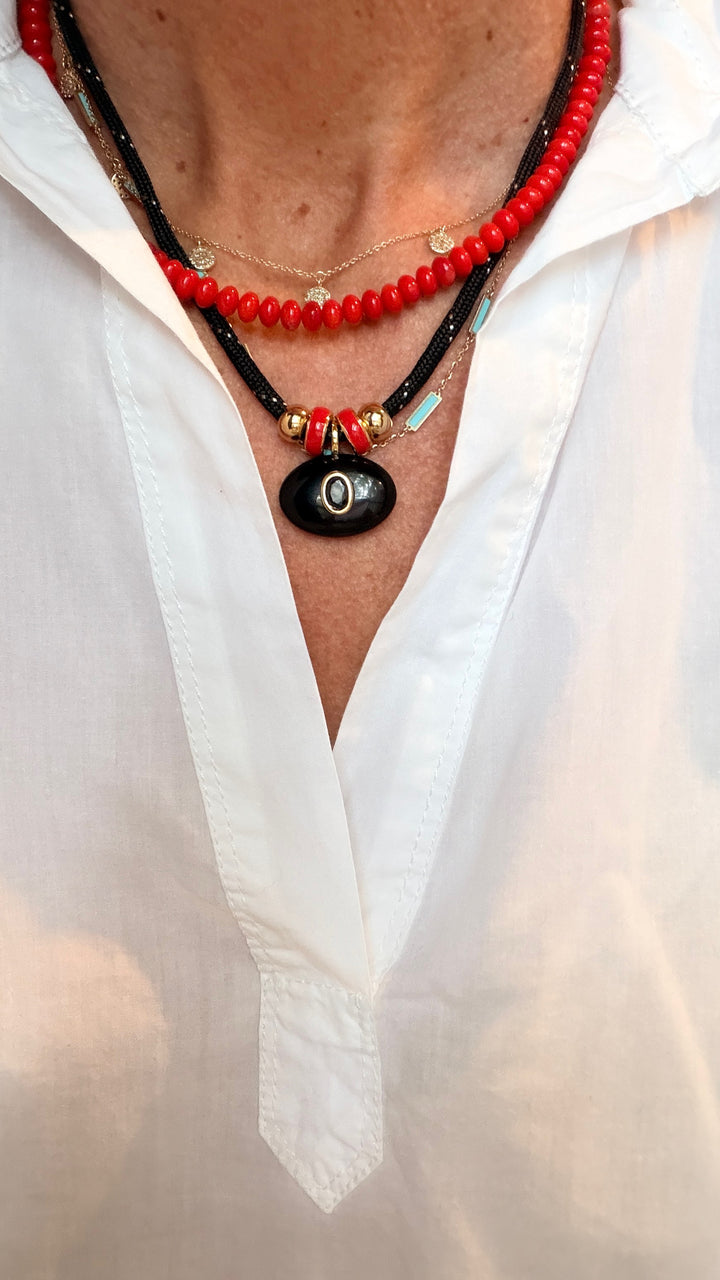 Black Oval Pendant with Red Spacers on a Black Cord Necklace