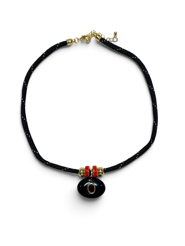 Black Oval Pendant with Red Spacers on a Black Cord Necklace